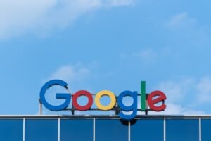 Google logo on top of a building against a blue sky background.